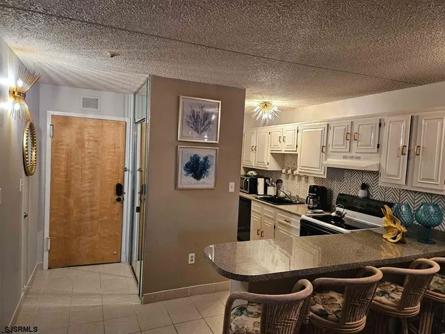 a kitchen with stainless steel appliances granite countertop a sink refrigerator and cabinets