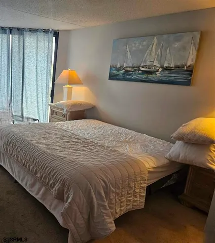 a bedroom with a bed and painting on the wall