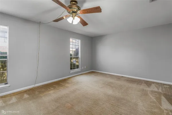 a view of an empty room with wooden floor and window