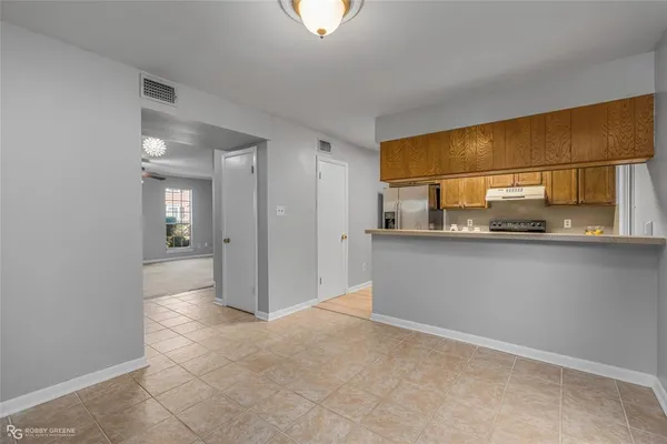 a view of a kitchen with a fridge and wooden floor