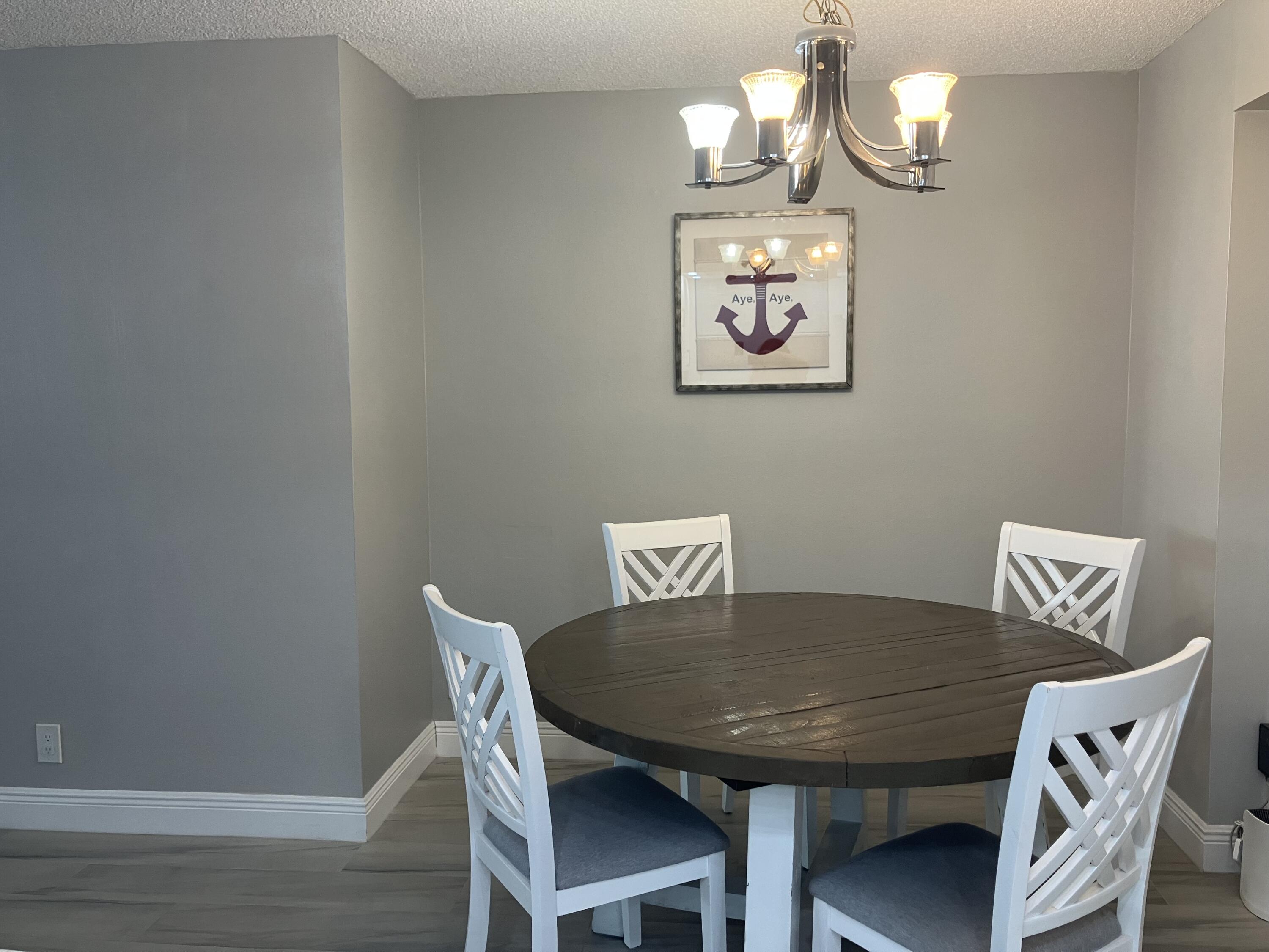111 Briny Avenue, Unit 703 Pompano Beach, FL 33062 - Photo 5 of 19 a view of a dining room with furniture and chandelier