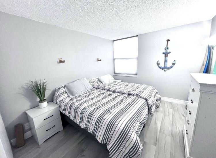 111 Briny Avenue, Unit 703 Pompano Beach, FL 33062 - Photo 8 of 19 a bedroom with a bed and a potted plant