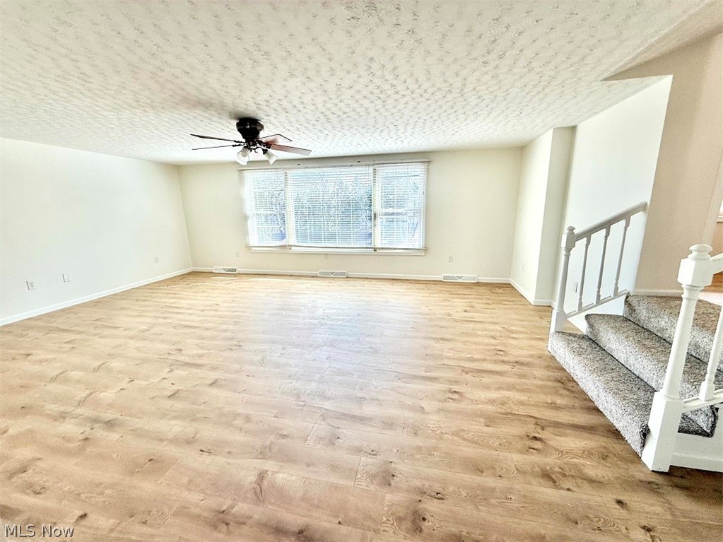 144 Aberdeen Road Steubenville, OH 43953 - Photo 7 of 34 Empty room with a ceiling fan, light wood-type flooring, and a textured ceiling