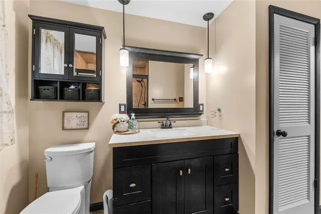 a bathroom with a sink vanity mirror and toilet