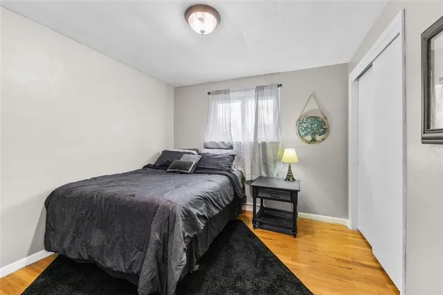 a bed sitting in a spacious bedroom next to a window