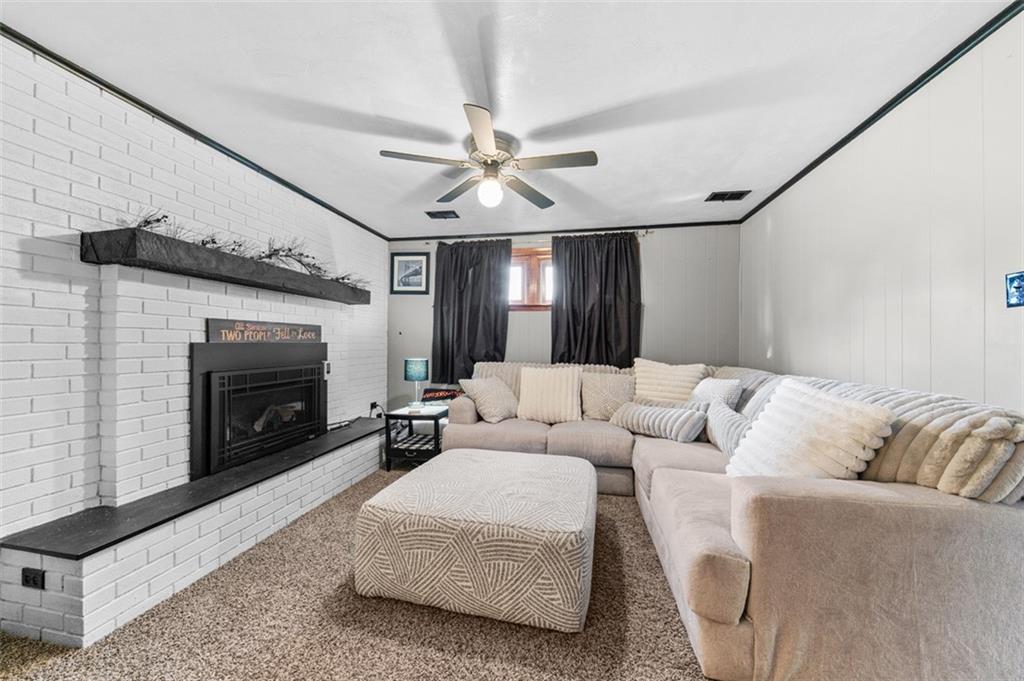 708 Hancock Street Perryopolis, PA 15473 - Photo 25 of 36 a living room with furniture a fireplace and a flat screen tv