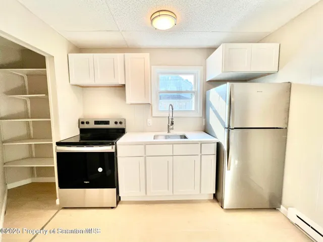 a kitchen with stainless steel appliances a refrigerator sink and cabinets