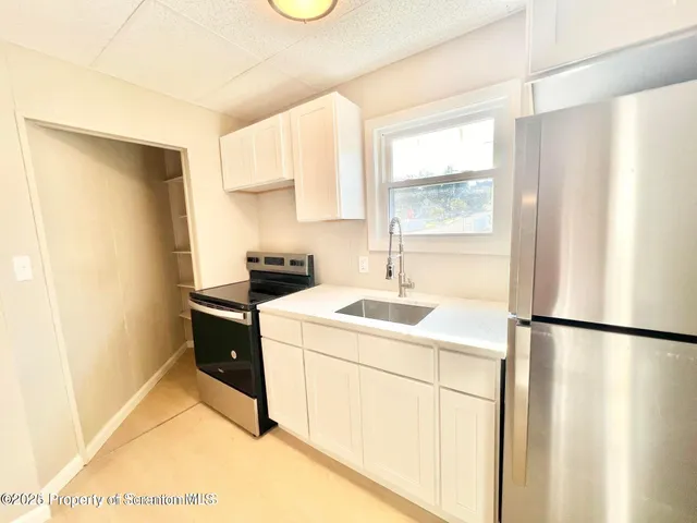 a kitchen with a sink and a refrigerator