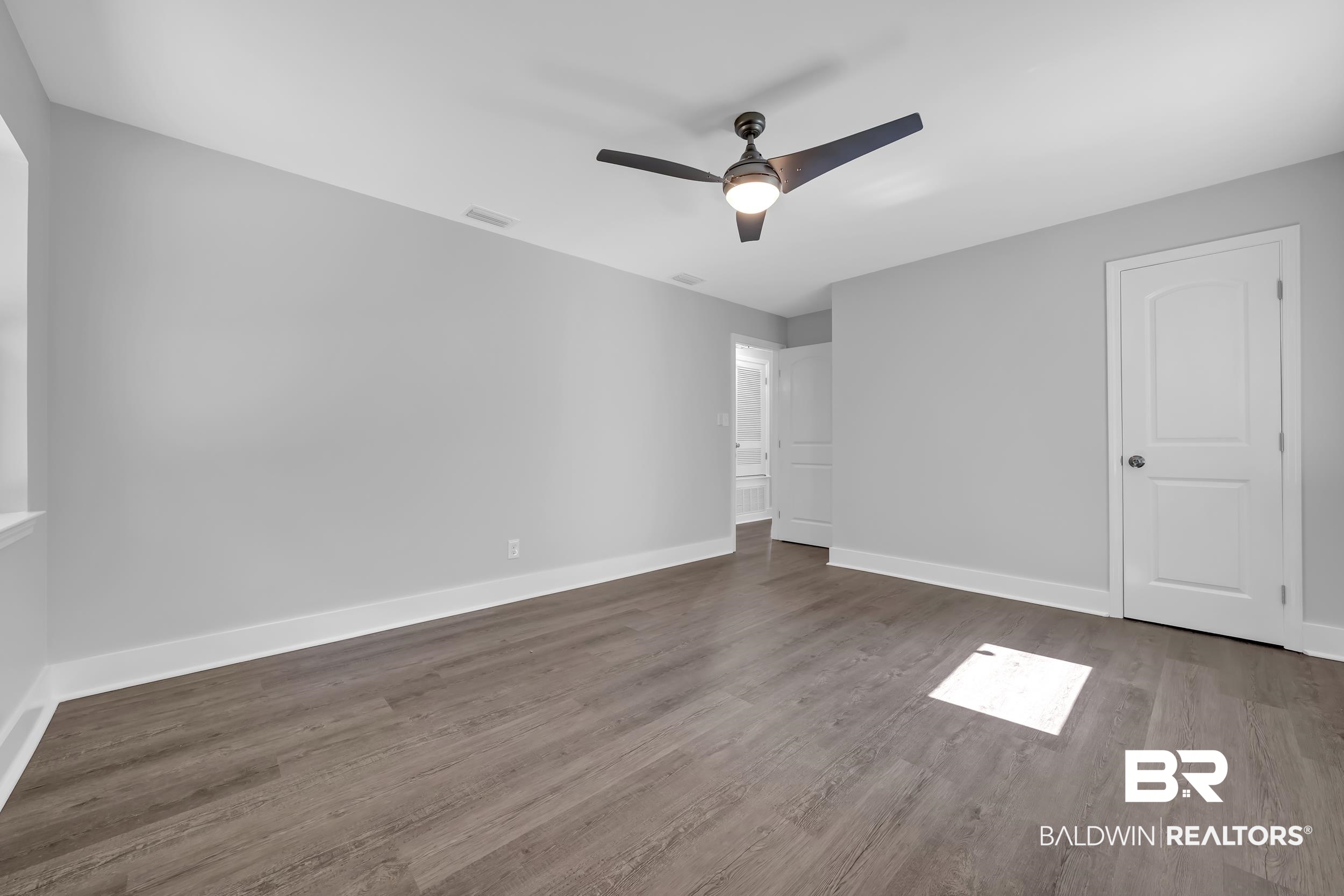2712 Shelton Beach Rd Extension Mobile, AL 36613 - Photo 15 of 24 Spacious room featuring wood-finish flooring, light grey walls, and white baseboards