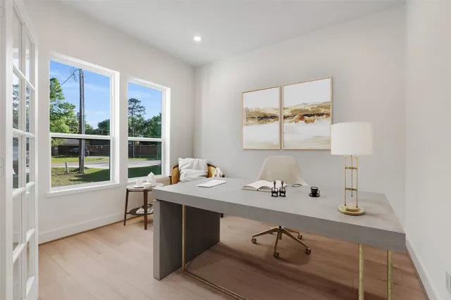 a view of a workspace with furniture and a window