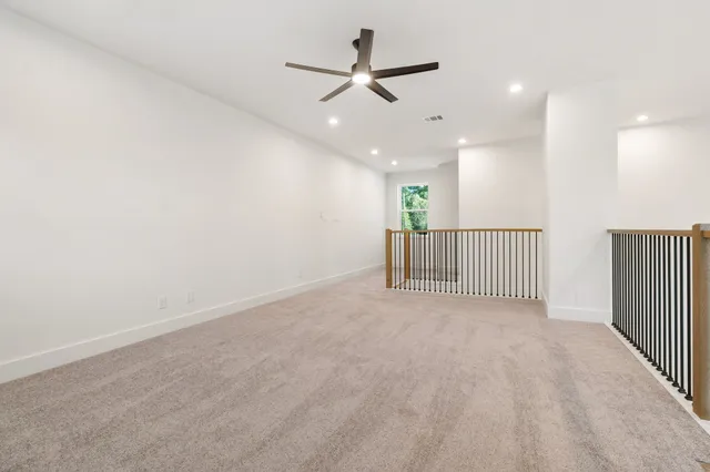 en view of a livingroom with a ceiling fan and window