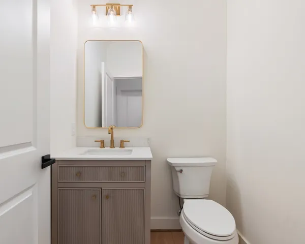 a bathroom with a toilet a sink and mirror