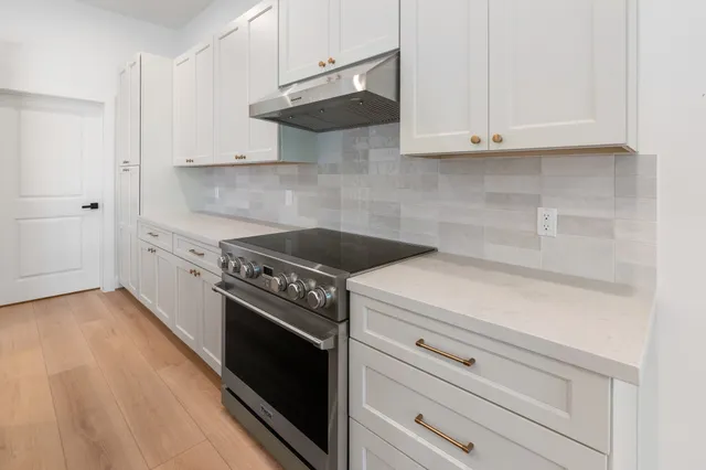 a kitchen with white cabinets and a stove