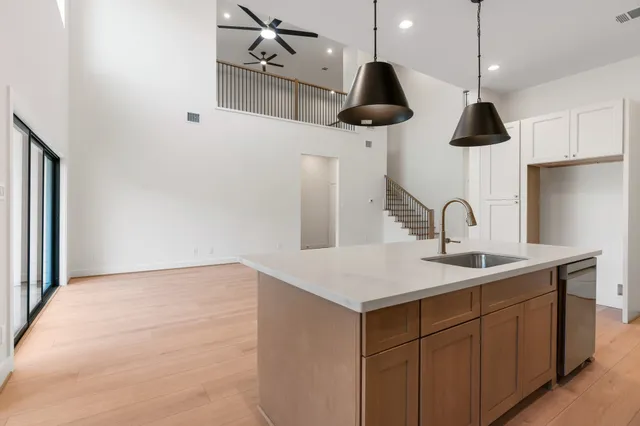 a kitchen with a sink a chandelier and wooden floor