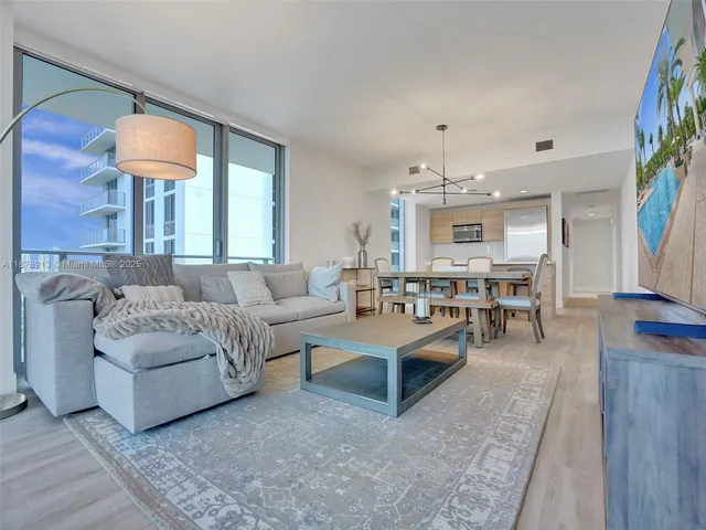 a living room with furniture and a chandelier