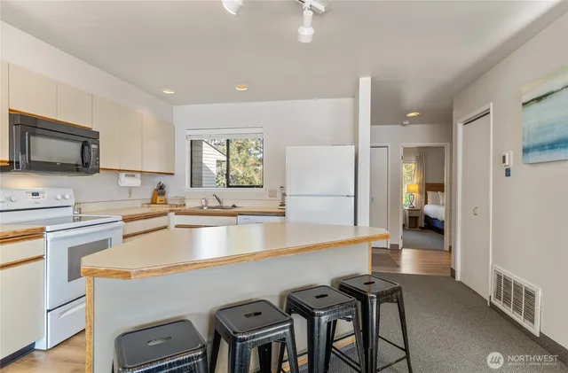 a kitchen with a table chairs refrigerator and cabinets