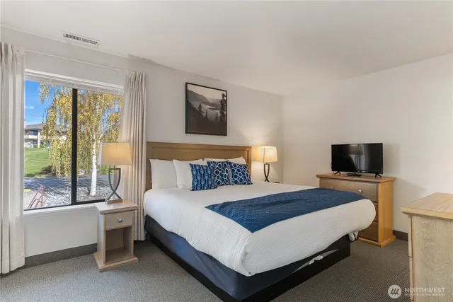 a bedroom with a bed and a flat screen tv