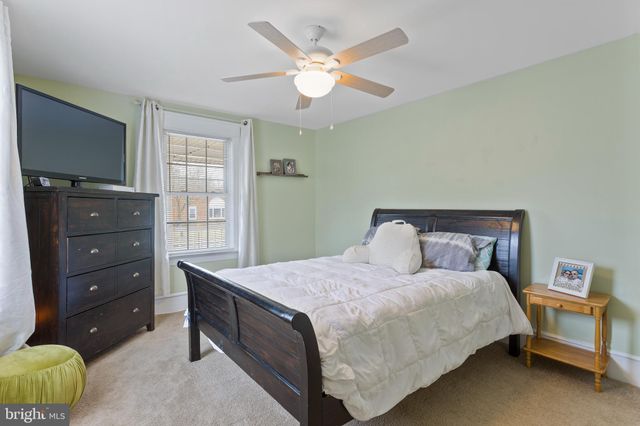 a bedroom with a bed and a flat tv screen on dresser