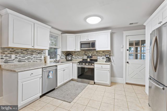 a kitchen with cabinets stainless steel appliances and a sink