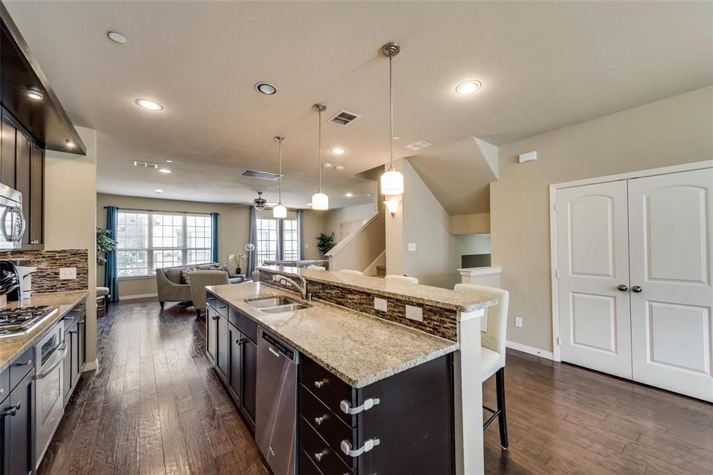 3943 Asbury Lane Addison, TX 75001 - Photo 29 of 29 a kitchen with a stove a sink a counter space and wooden floor