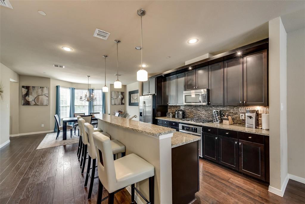 3943 Asbury Lane Addison, TX 75001 - Photo 14 of 29 a large kitchen with a table and chairs