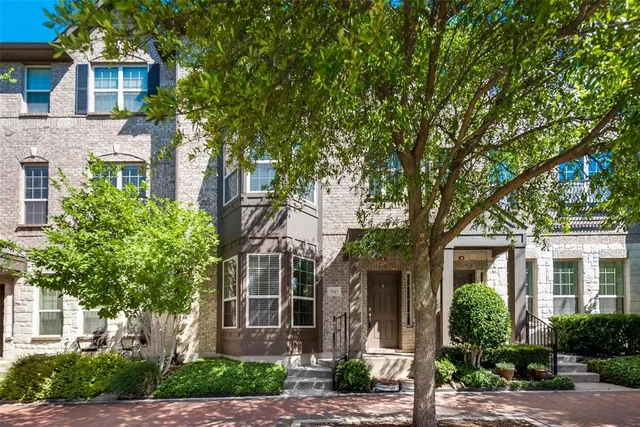 a front view of a house with a tree