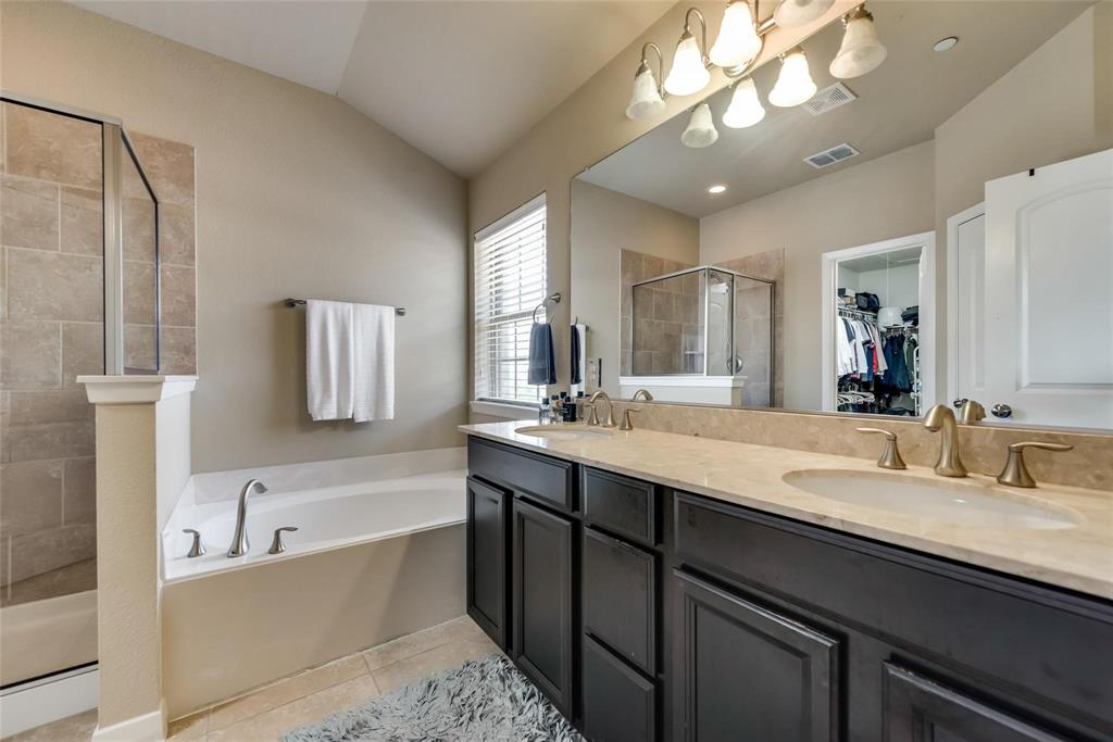 3943 Asbury Lane Addison, TX 75001 - Photo 21 of 29 a bathroom with a bathtub double vanity sink and a mirror