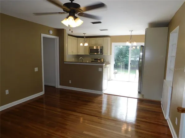 a view of a kitchen with wooden floor and a ceiling fan