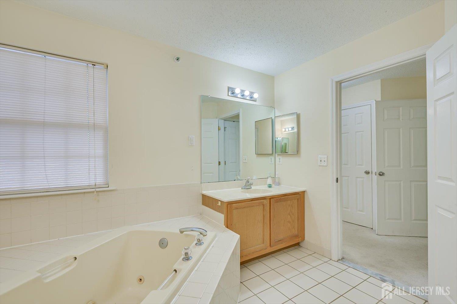 27 Edinburgh Court Edison, NJ 08820 - Photo 11 of 15 a spacious bathroom with a tub sink and mirror