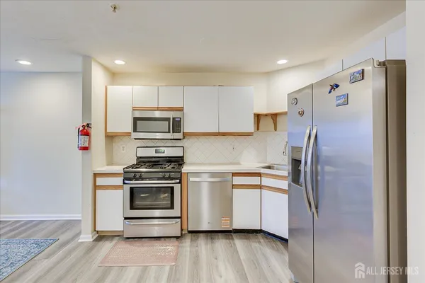 a kitchen with stainless steel appliances a refrigerator and a stove top oven