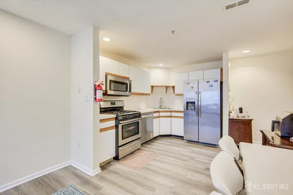a kitchen with granite countertop a refrigerator stove top oven and sink