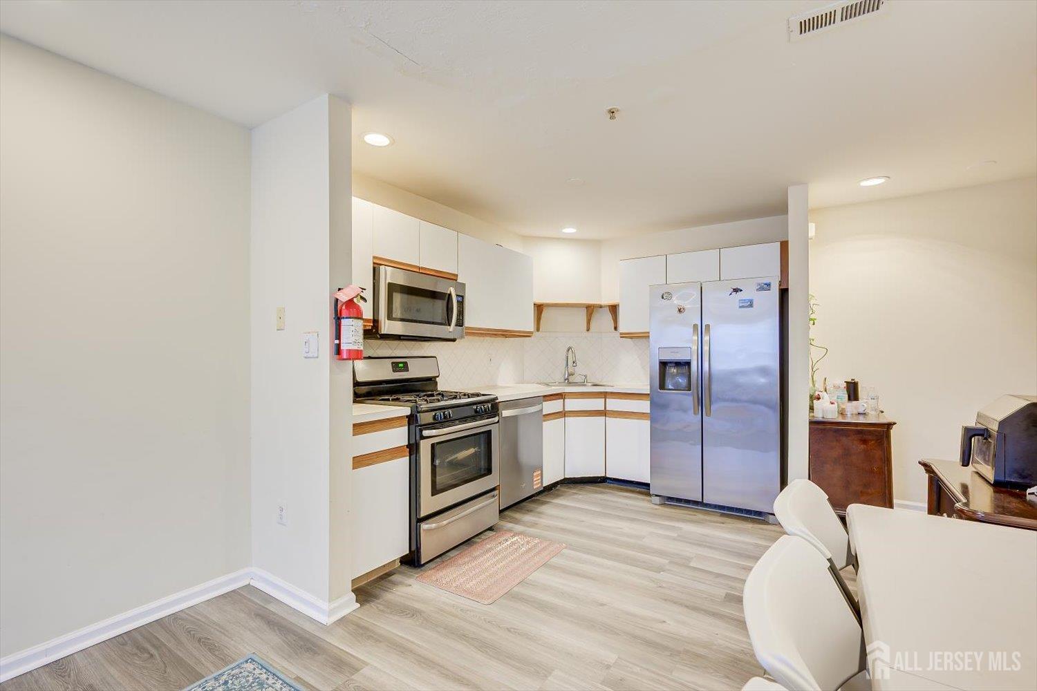 27 Edinburgh Court Edison, NJ 08820 - Photo 4 of 15 a kitchen with granite countertop a refrigerator stove top oven and sink