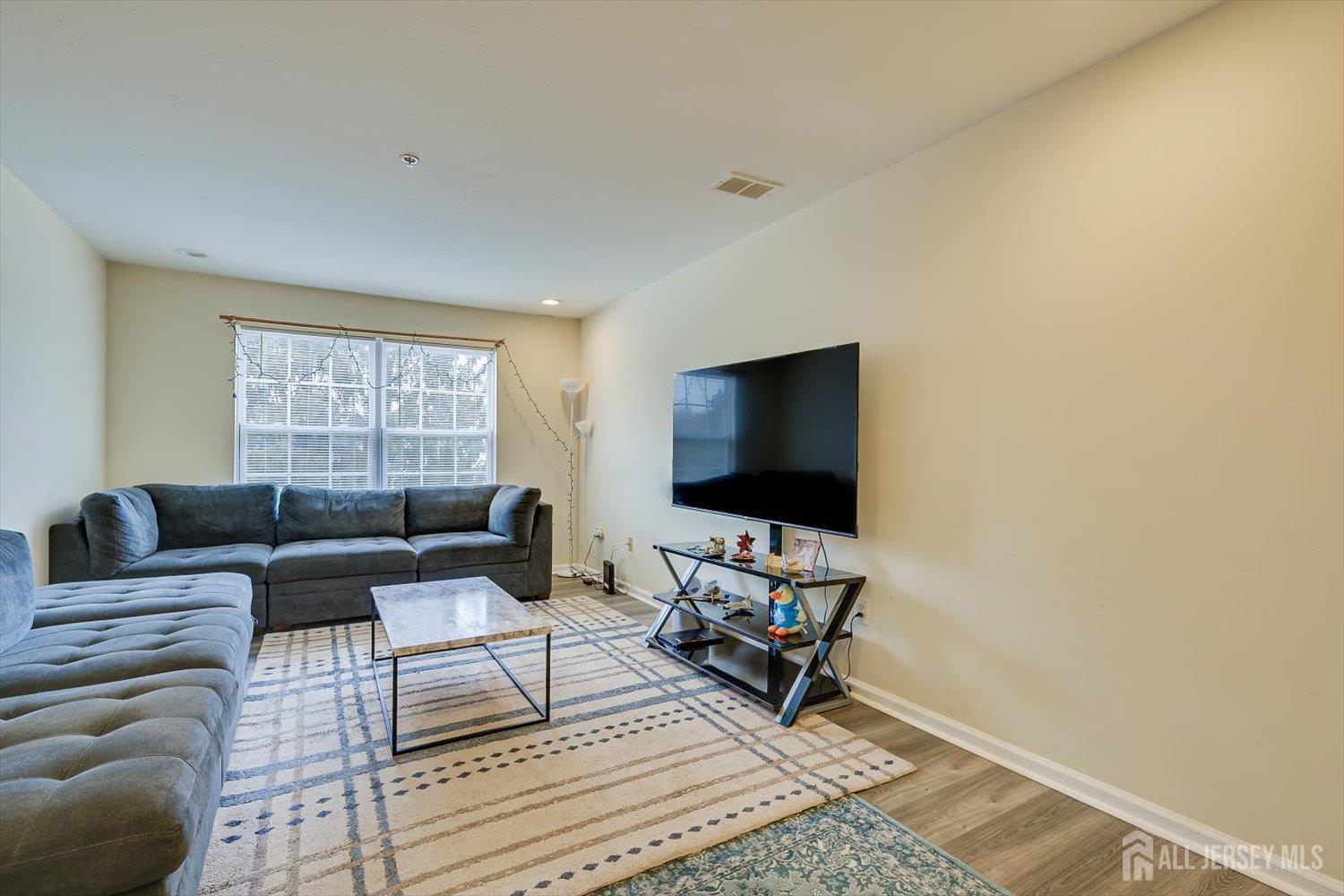 27 Edinburgh Court Edison, NJ 08820 - Photo 7 of 15 a living room with furniture and a flat screen tv