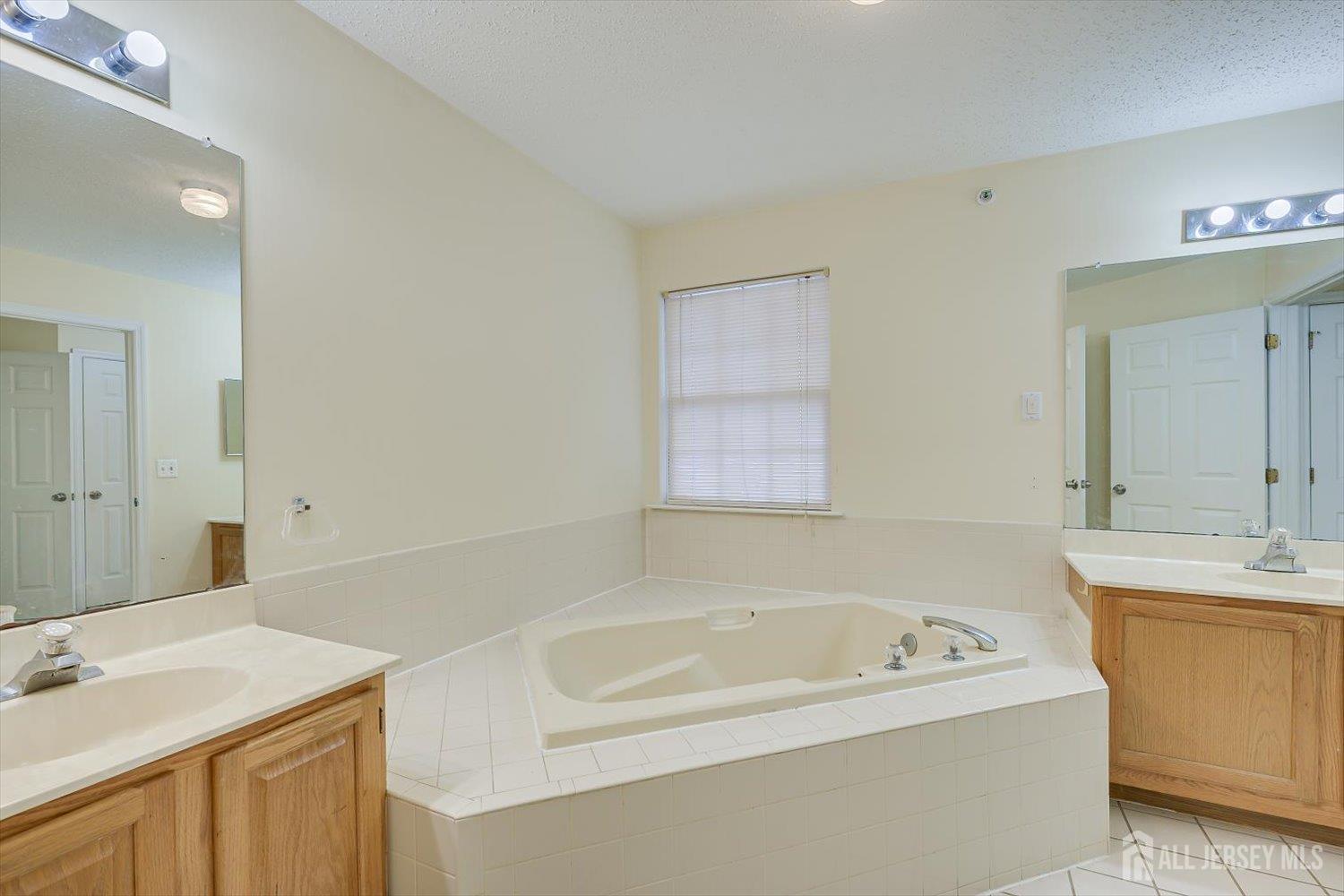 27 Edinburgh Court Edison, NJ 08820 - Photo 9 of 15 a view of a bathroom with a tub sink and mirror