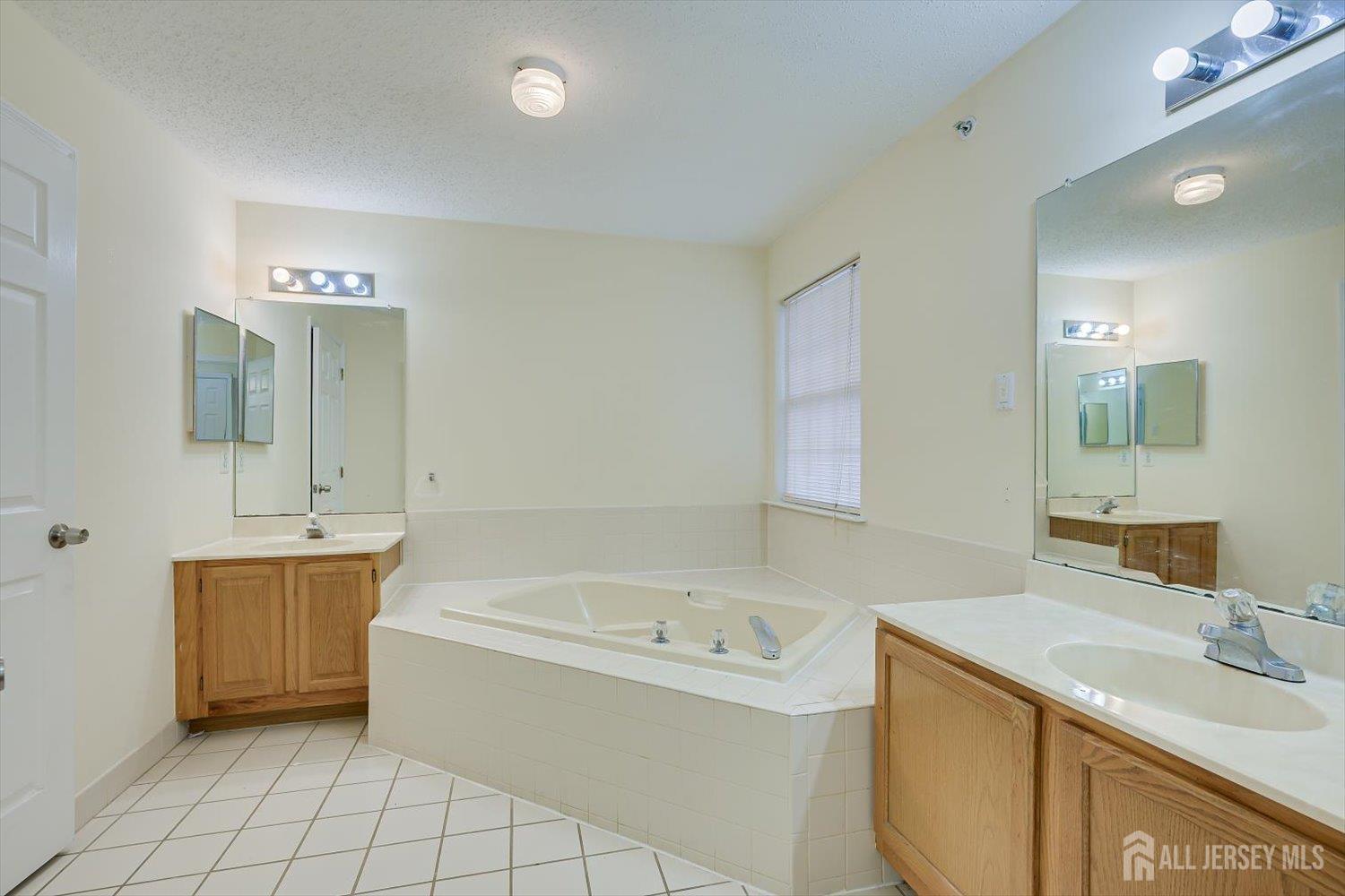 27 Edinburgh Court Edison, NJ 08820 - Photo 10 of 15 a bathroom with a tub sink and mirror