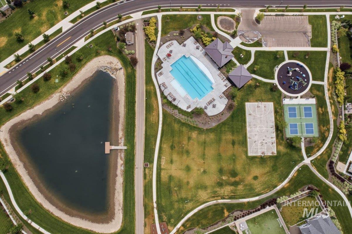 5897 West Riva Capri Street Meridian, ID 83646 - Photo 46 of 50 Community amenities featuring a swimming pool, basketball court, tennis courts, and playground areas, surrounded by green spaces and a pond with a dock