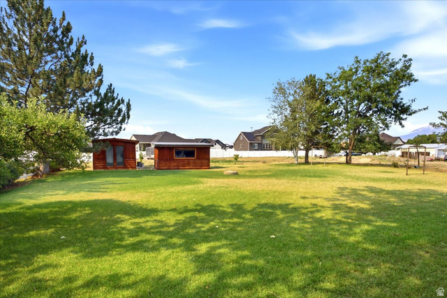 2252 West 800 North Clinton, UT 84015 - Photo 30 of 38 Expansive green lawn with two wood-clad outbuildings