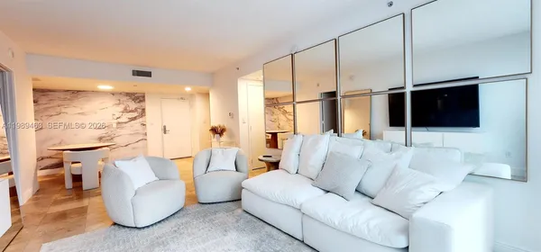 a living room with furniture a flat screen tv and a large window