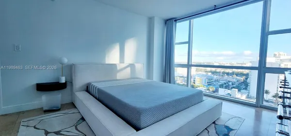 a bedroom with a bed and a large window