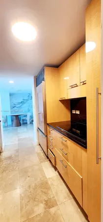 a view of an empty room and kitchen with furniture