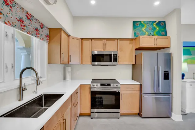 a kitchen with stainless steel appliances granite countertop a refrigerator and a sink