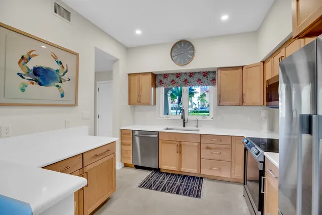 a kitchen with stainless steel appliances a stove refrigerator and a sink