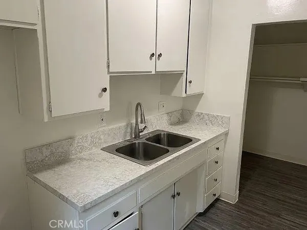 a kitchen with granite countertop a sink and a refrigerator