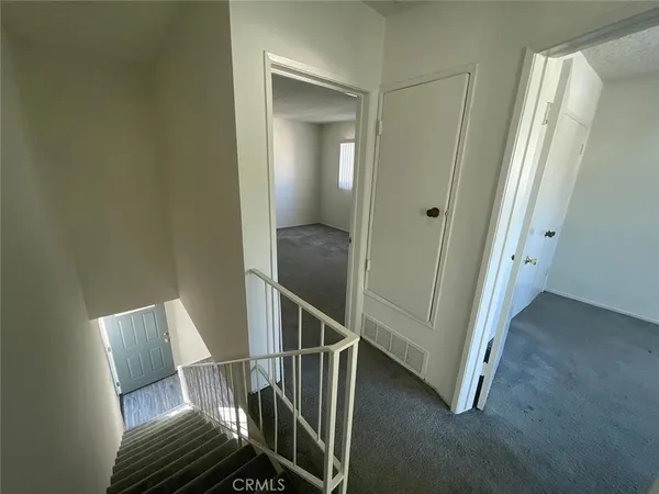 a view of a hallway with wooden floor and entryway