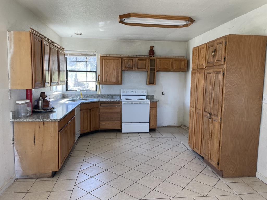 2385 Lakeview Loop Stonyford, CA 95979 - Photo 6 of 20 a kitchen with stainless steel appliances granite countertop a sink counter space cabinets and a large window