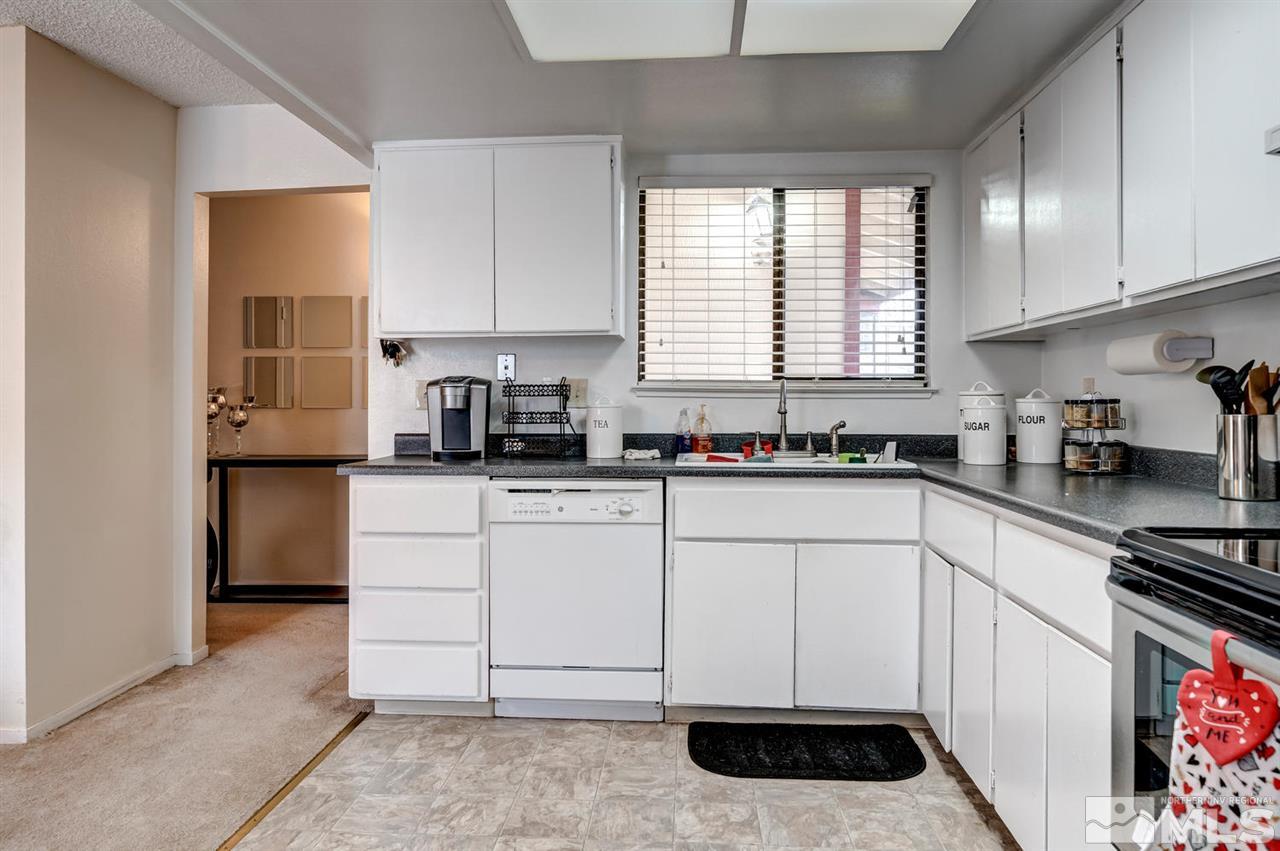 3315 Bowie Road Reno, NV 89503 - Photo 3 of 35 a kitchen with white cabinets a sink a window and stainless steel appliances