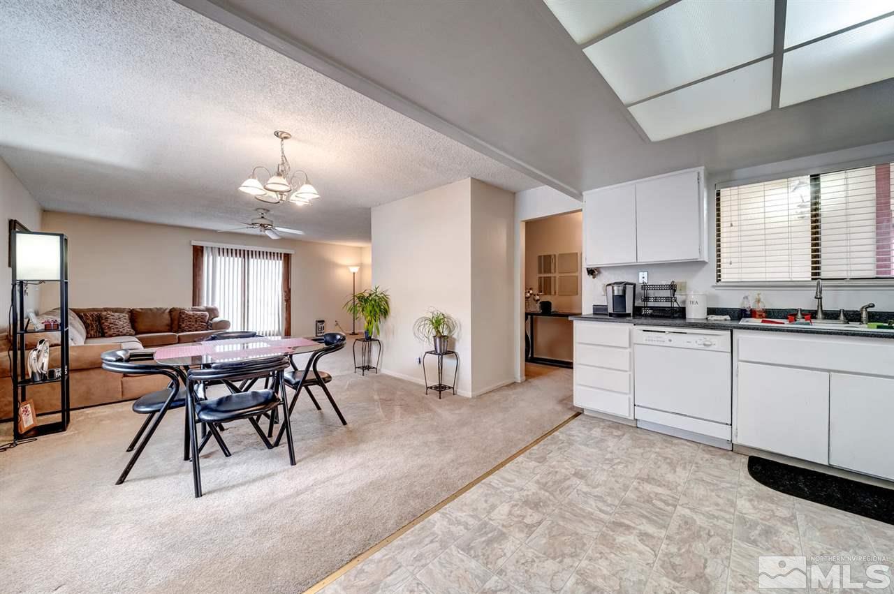 3315 Bowie Road Reno, NV 89503 - Photo 8 of 35 a kitchen with stainless steel appliances kitchen island granite countertop a table chairs sink and cabinets