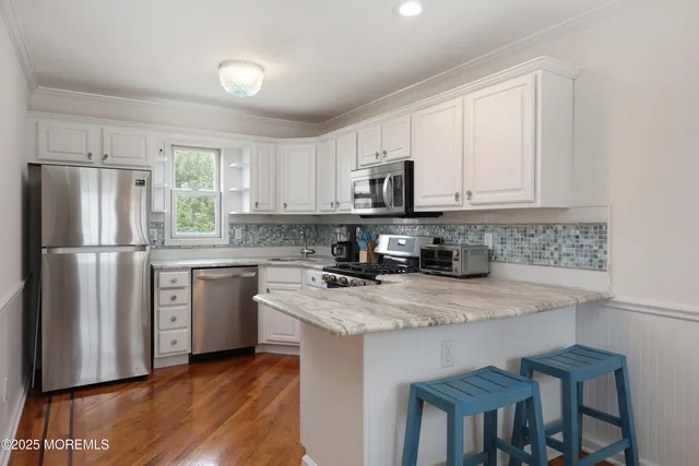 a kitchen with white cabinets and stainless steel appliances