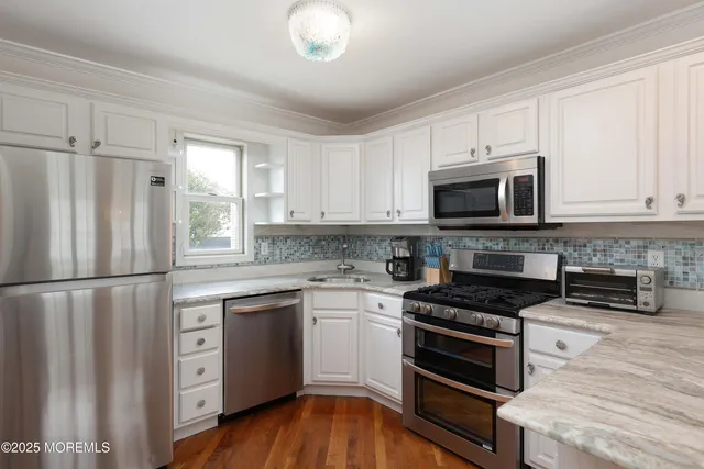 a kitchen with stainless steel appliances granite countertop a stove a sink and a microwave