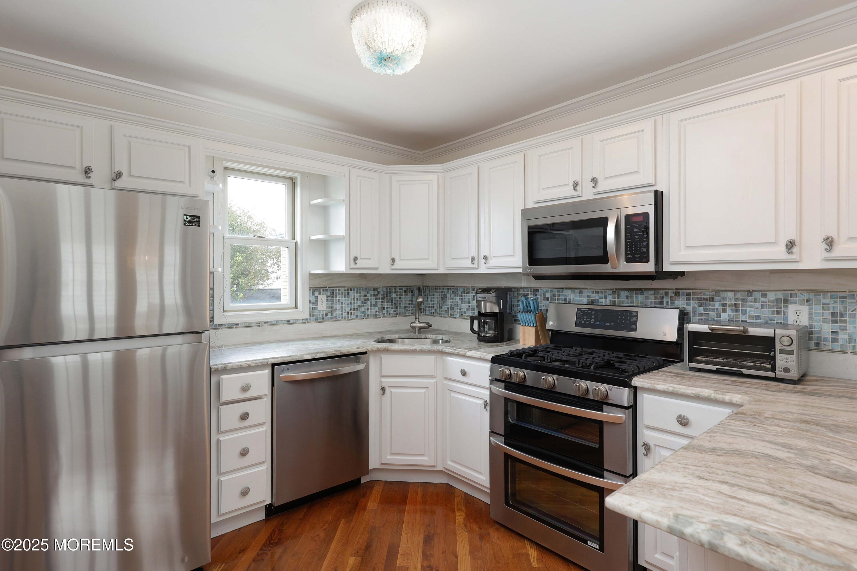 200 2nd Avenue, Unit 14 Belmar, NJ 07719 - Photo 19 of 32 a kitchen with white cabinets and stainless steel appliances